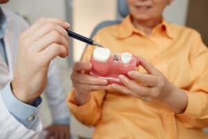 Woman having a consultation with her dentist about replacing her damaged dental crown using CEREC